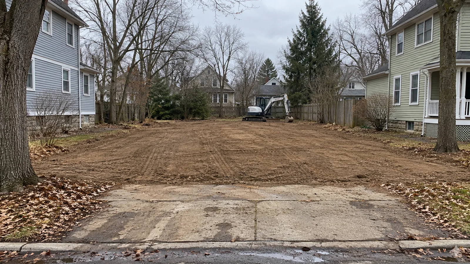 Rough-graded lot with fresh fill where an old house was removed on an overcast late-fall day